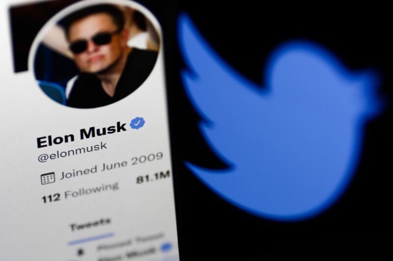 El perfil de Twitter de Elon Musk se muestra en la pantalla de una computadora junto con el logotipo de Twitter que se muestra en la pantalla de un teléfono