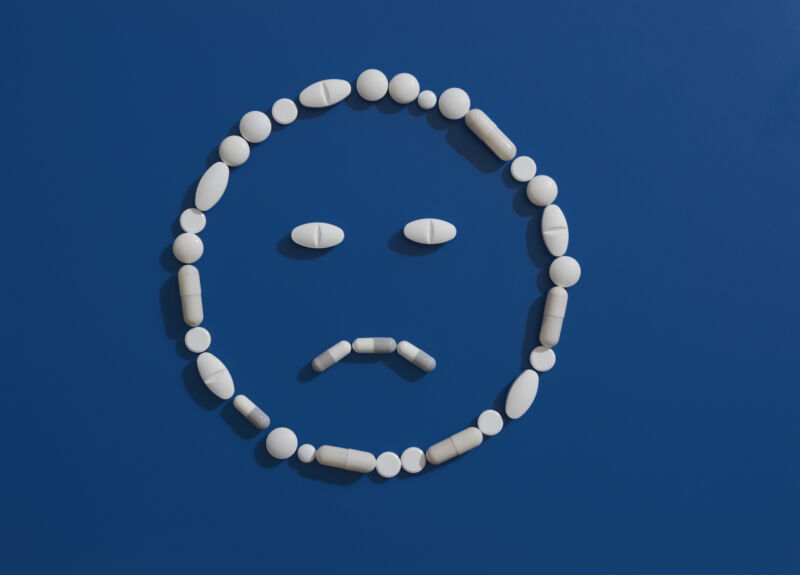 Imagen de una cara sonriente con el ceño fruncido, con líneas dibujadas con pastillas.