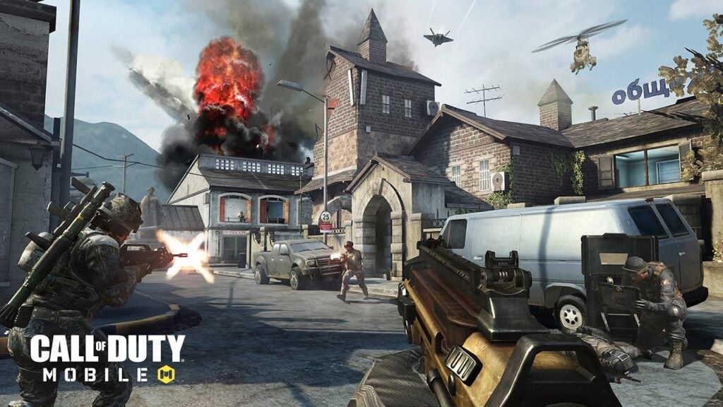 Una captura de pantalla del juego Call of Duty Mobile.  La captura de pantalla muestra una toma POV de un jugador que ataca a los soldados en un pueblo devastado por la guerra, con compañeros de equipo a cada lado de ellos.  Explosiones, helicópteros y aviones de combate suceden en el cielo.