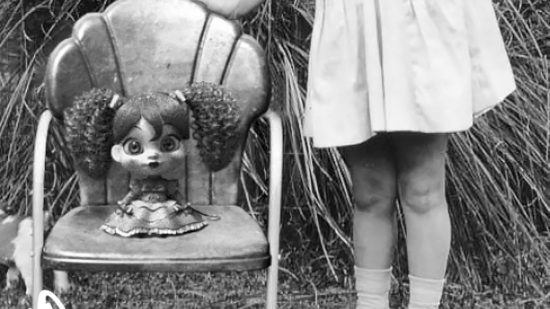 Una foto antigua de Poppy Playtime Poppy está sentada en una silla junto a una niña